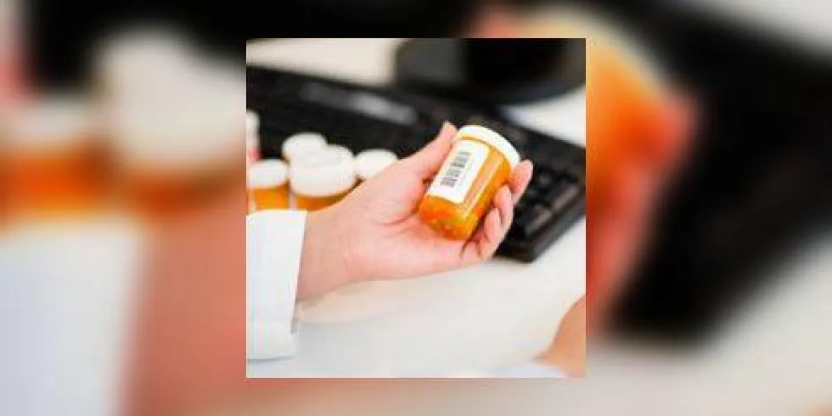 pharmacien avec des bouteilles de pilules à l'ordinateur