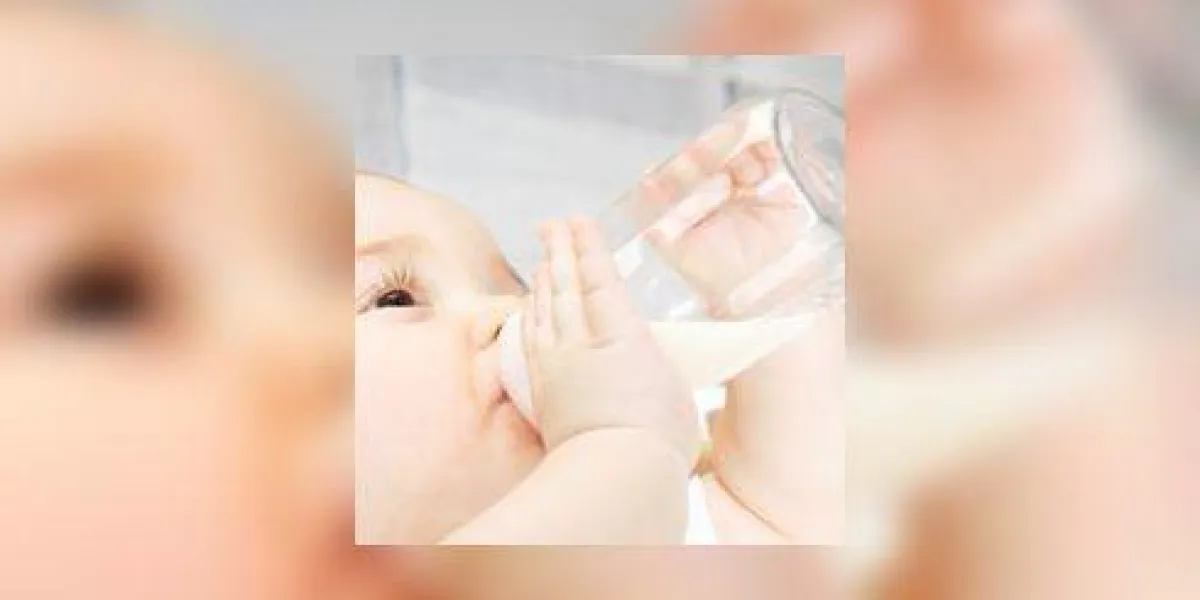 bébé fille (6-9 mois) bouteille de boisson, vue de côté, gros plan