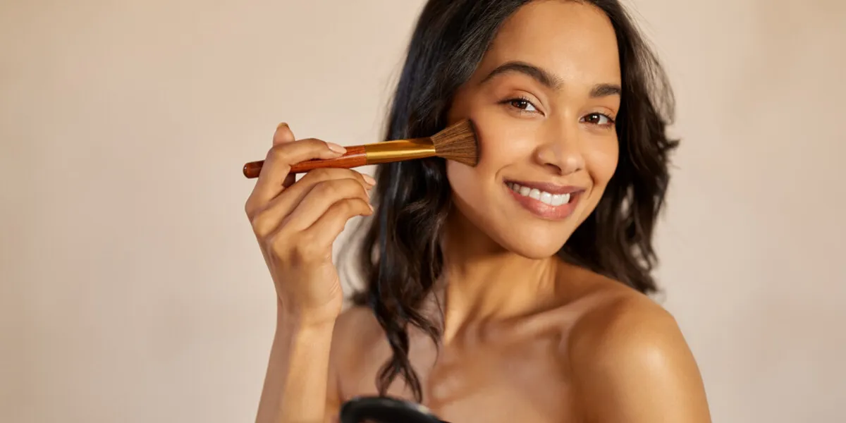 happy latin beauty woman applying makeup powder