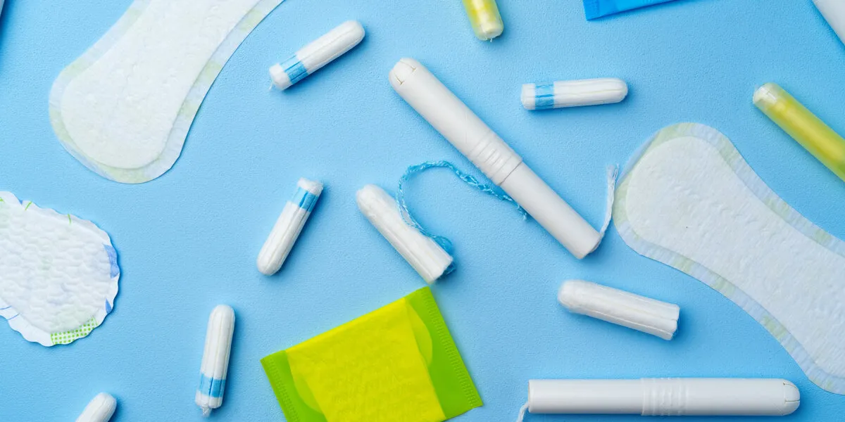 female hygienic pad and tampons on blue background top view