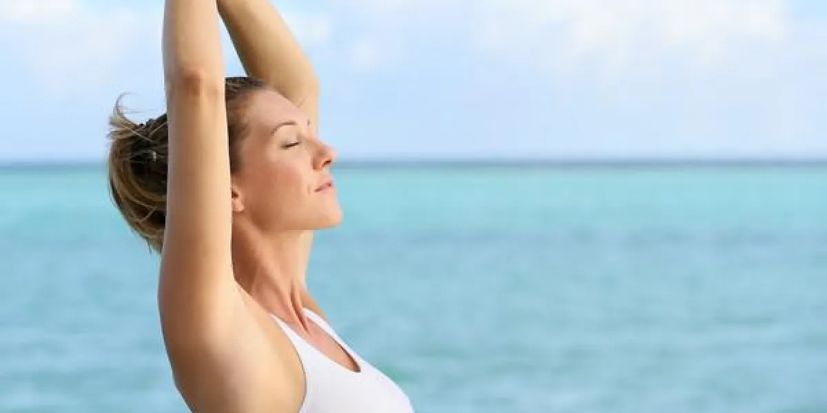 portrait de femme de fitness qui s'étend sur la mer