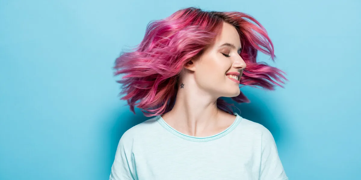 young woman waving pink hair on blue background