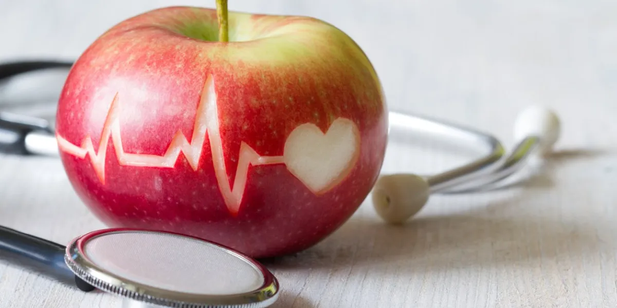 heartbeat line on red apple and stethoscope, healthy heart diet concept background