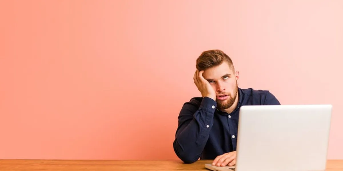 young man working with his laptop who is bored, fatigued and need a relax day