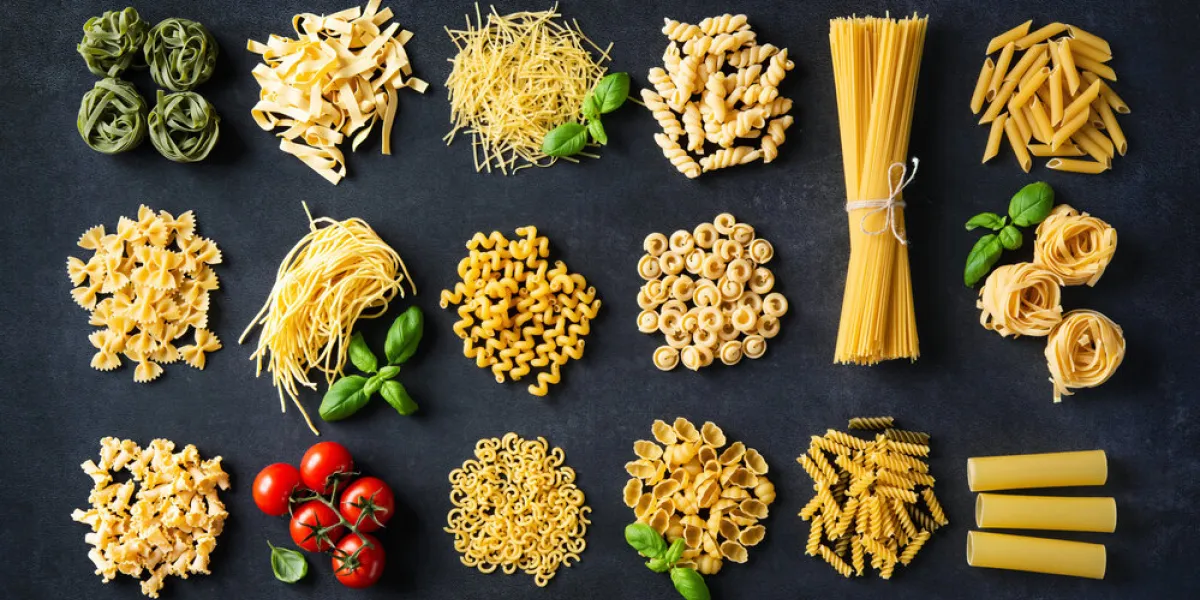 various pasta over stone background top view with copy space