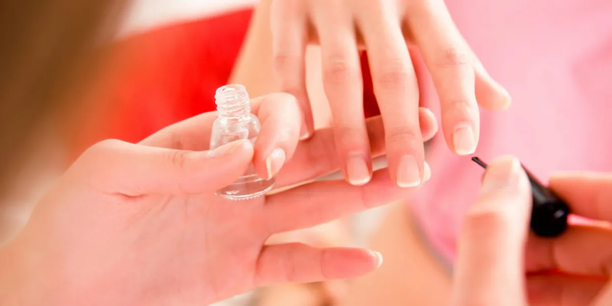 closeup photo of girls painting nails with varnish