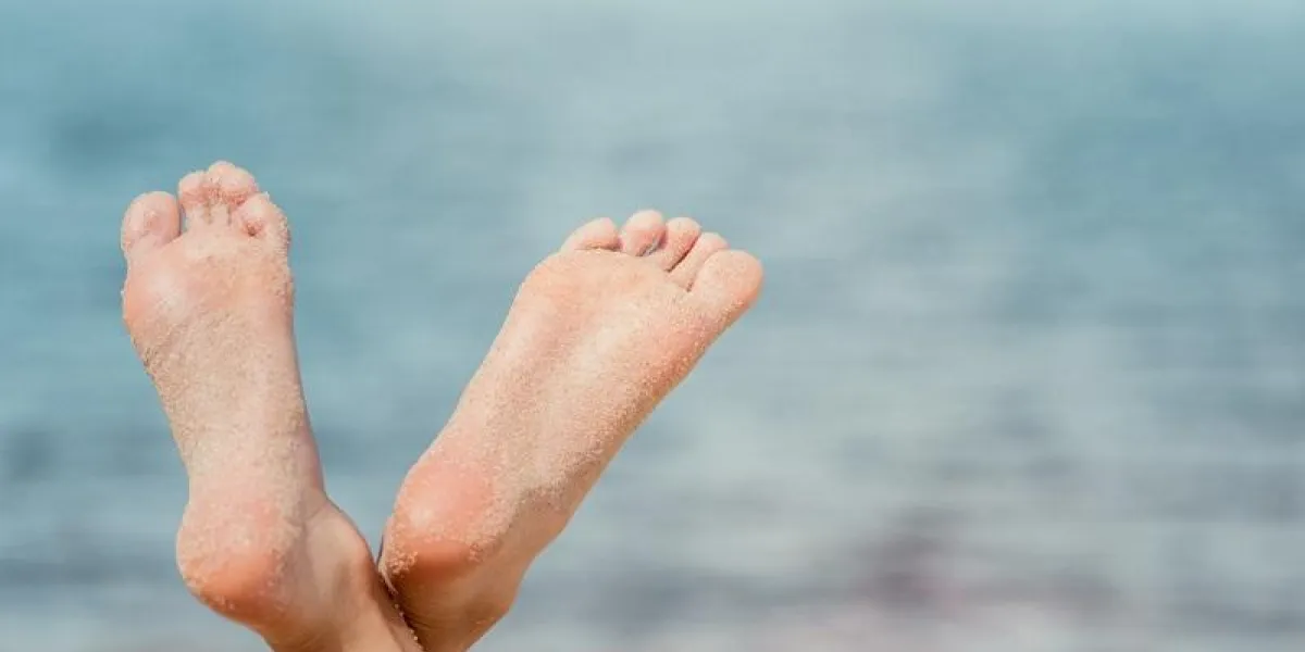 cropped view of barefoot woman on beach near the sea cropped view of barefoot woman on beach near the sea
