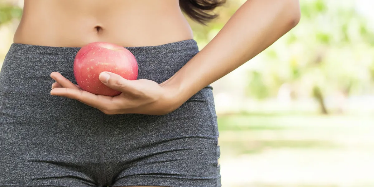 femelle saine tenant la pomme au niveau de la taille en plein air dans le parc