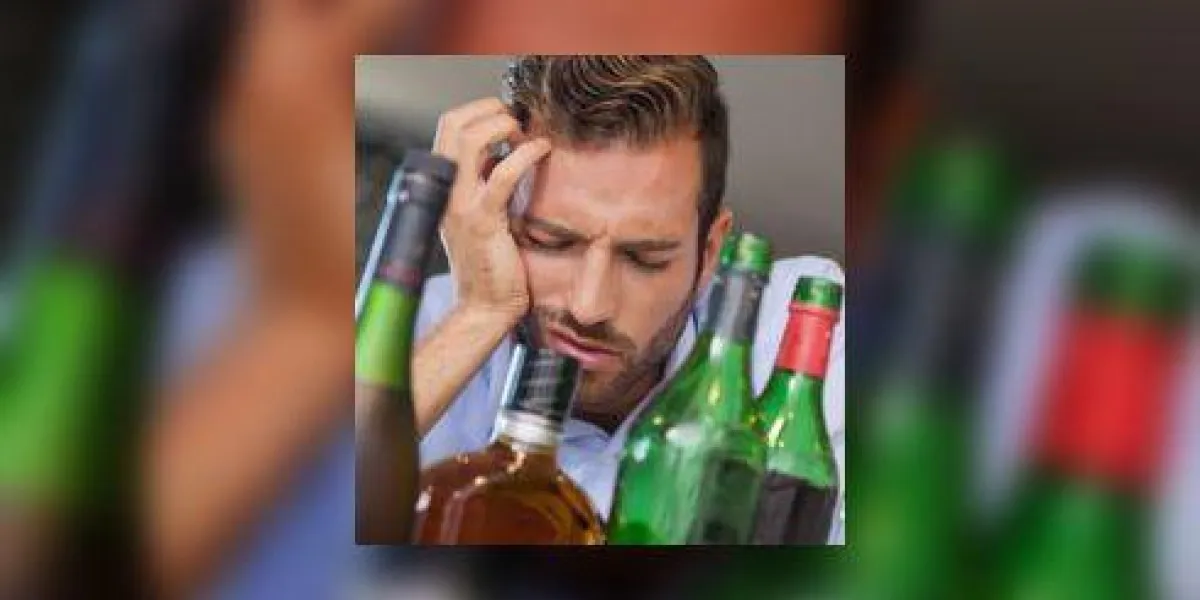 homme d'affaires ivre affalé à côté de nombreuses bouteilles d'alcool
