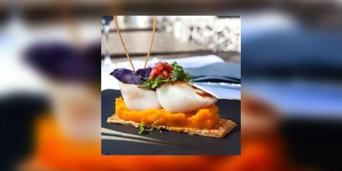 pétoncles saint-jacques, purée de carottes et biscuit sur une ardoise
