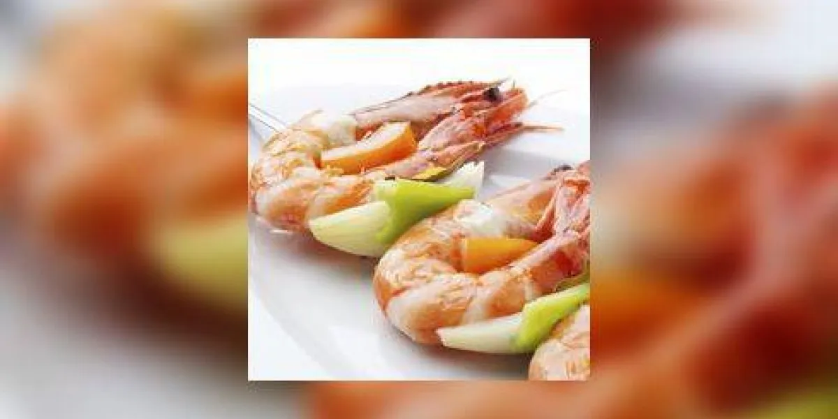 grosses crevettes bouillies juteuses servies sur une brochette sur une assiette