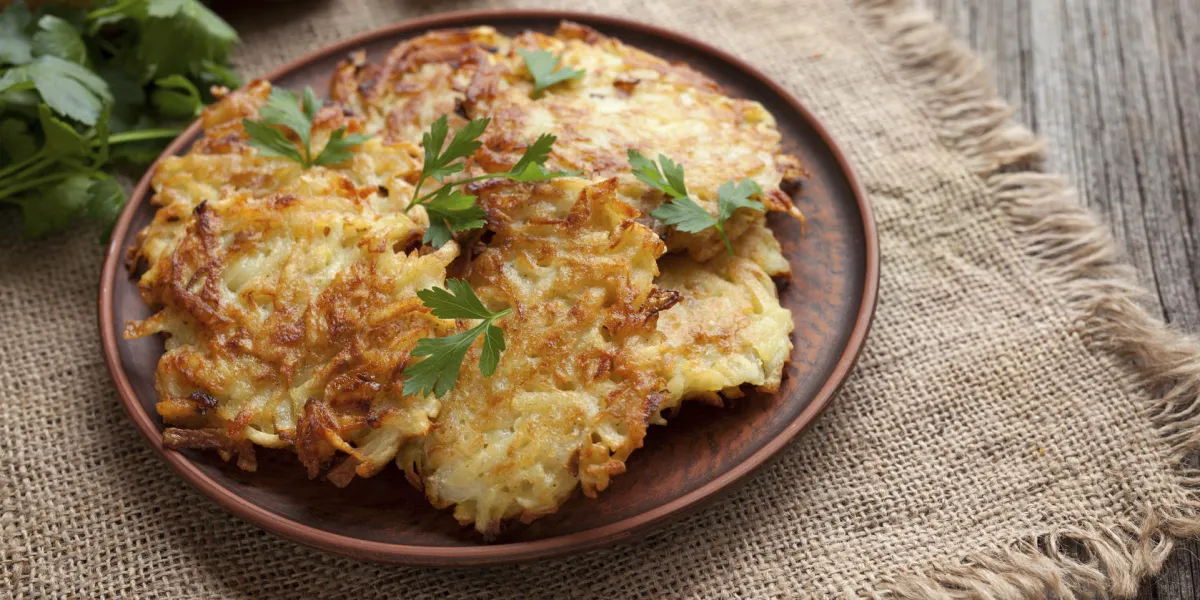 crêpes de pommes de terre traditionnelles ou latke maison nourriture juive hanukkah célébration recette maison vegan organique repas dans un plat d'argile sur vintage style rustique en bois
