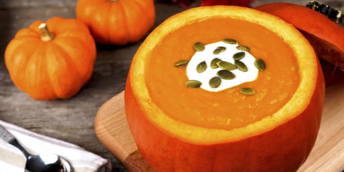 soupe d'automne crémeuse garnie de graines de citrouille et crème dans un bol de citrouille soupe d'automne crémeuse garnie de graines de citrouille et crème dans un bol de citrouille