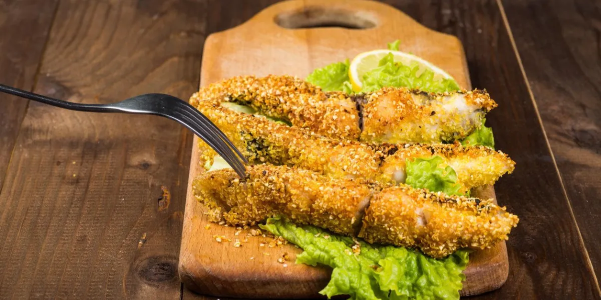 poisson frit sur une planche de bois avec de la laitue se bouchent poisson frit sur une planche de bois avec de la laitue se bouchent