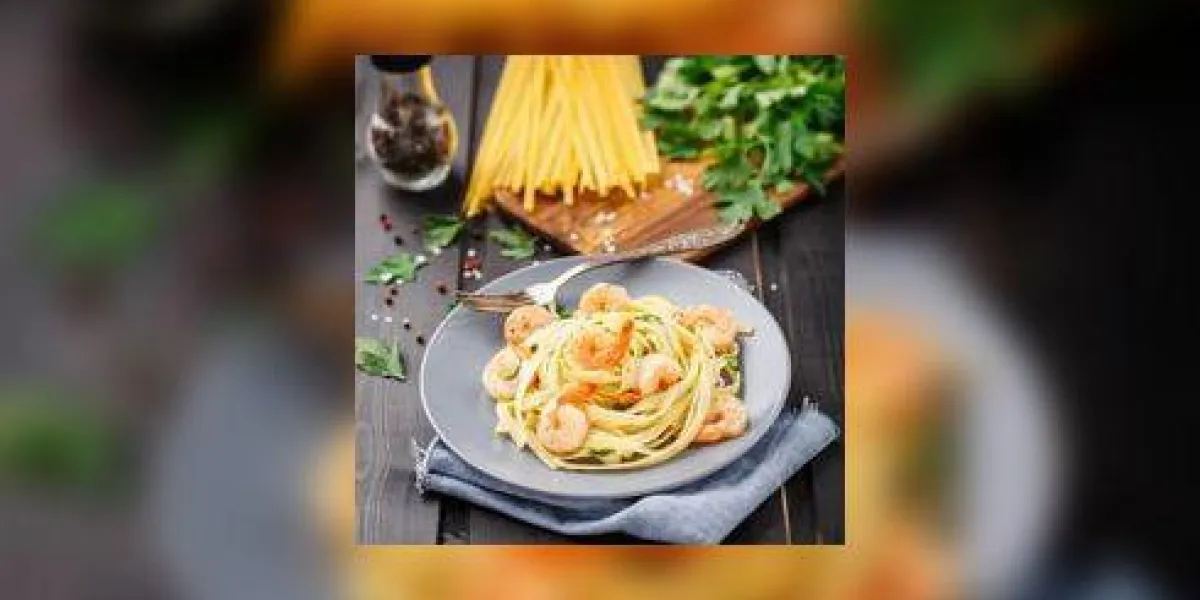 tagliatelle aux crevettes et au persil sur une assiette