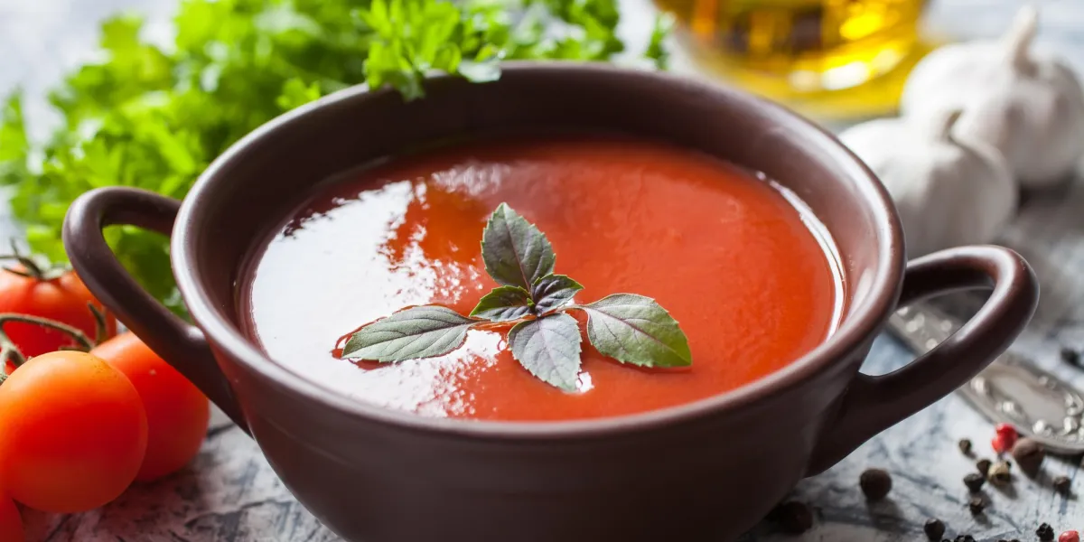 soupe de tomates avec un basilic dans un bol sur une table, mise au point sélective