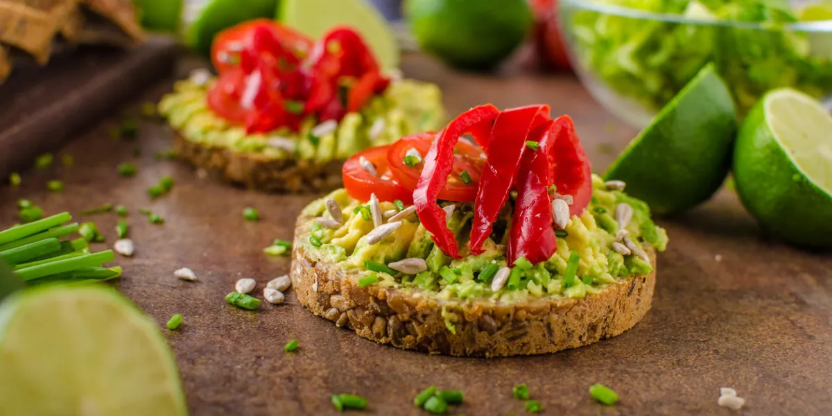 pain de blé entier avec beurre d'avocat, graines et poivre, avec des herbes et un peu de jus de citron vert pain de blé entier avec beurre d'avocat, graines et poivre, avec des herbes et un peu de jus de citron vert