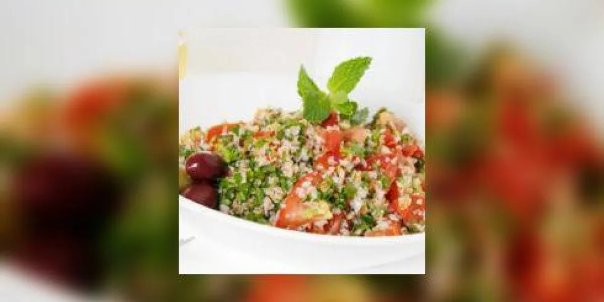 salade de taboulé dans un bol blanc avec une tasse de café et un verre de vin