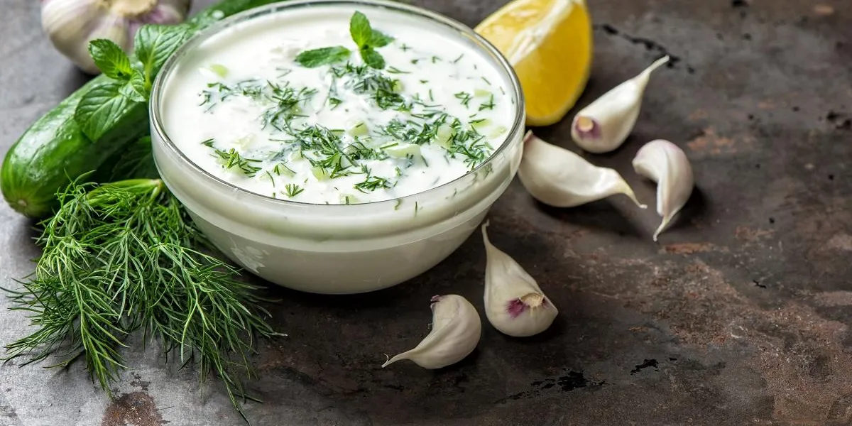 tzatziki sauce with ingredients cucumber, garlic, dill, lemon, mint healthy food background