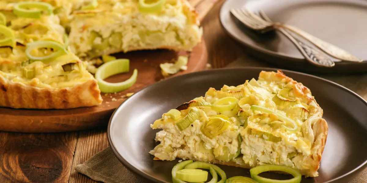quiche with leek and cheese on brown background quiche with leek and cheese on brown background