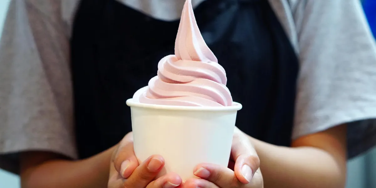 closeup of woman 's hand holding takeaway cup with organic frozen yogurt ice cream, it's delicious and healthy enjoy eating concept