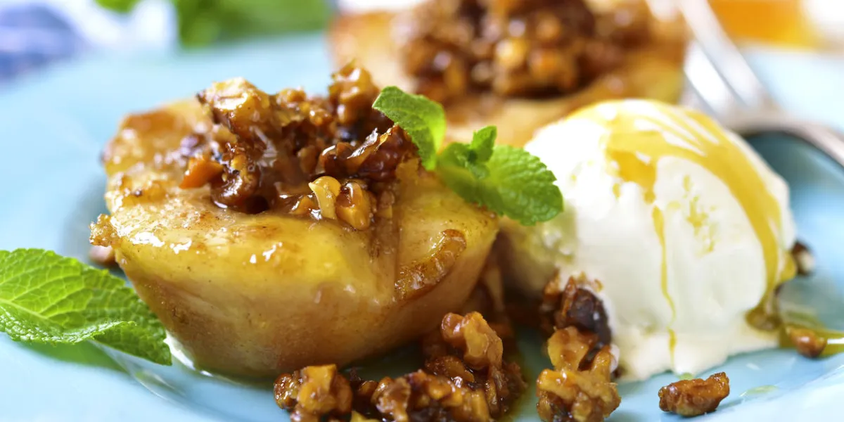 grilled pear with caramelized walnuts and honey on a blue vintage plate