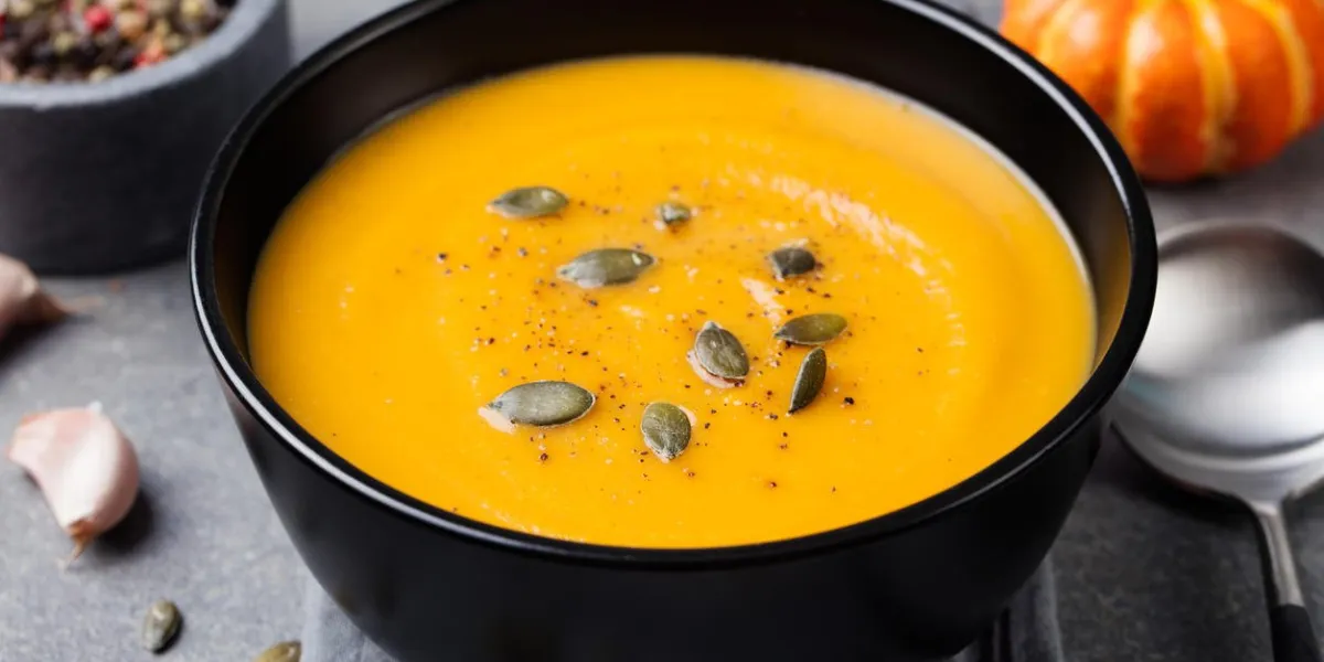soupe à la crème de citrouille avec des graines de citrouille dans un fond de pierre grise bol noir soupe à la crème de citrouille avec des graines de citrouille dans un fond de pierre grise bol noir