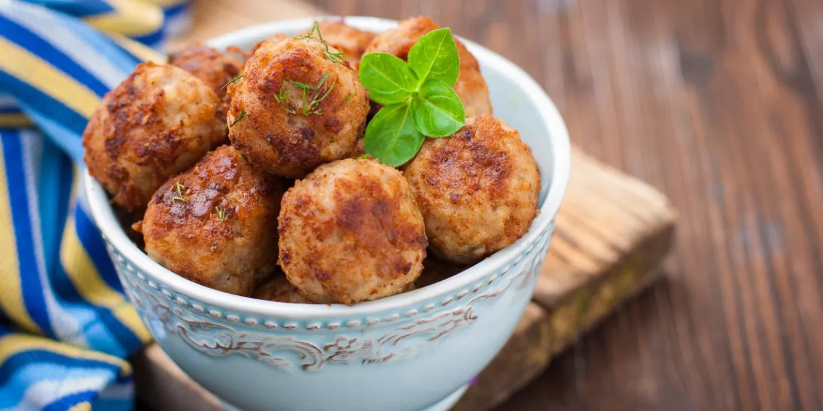boulettes de viande dans un bol bleu sur la table en bois