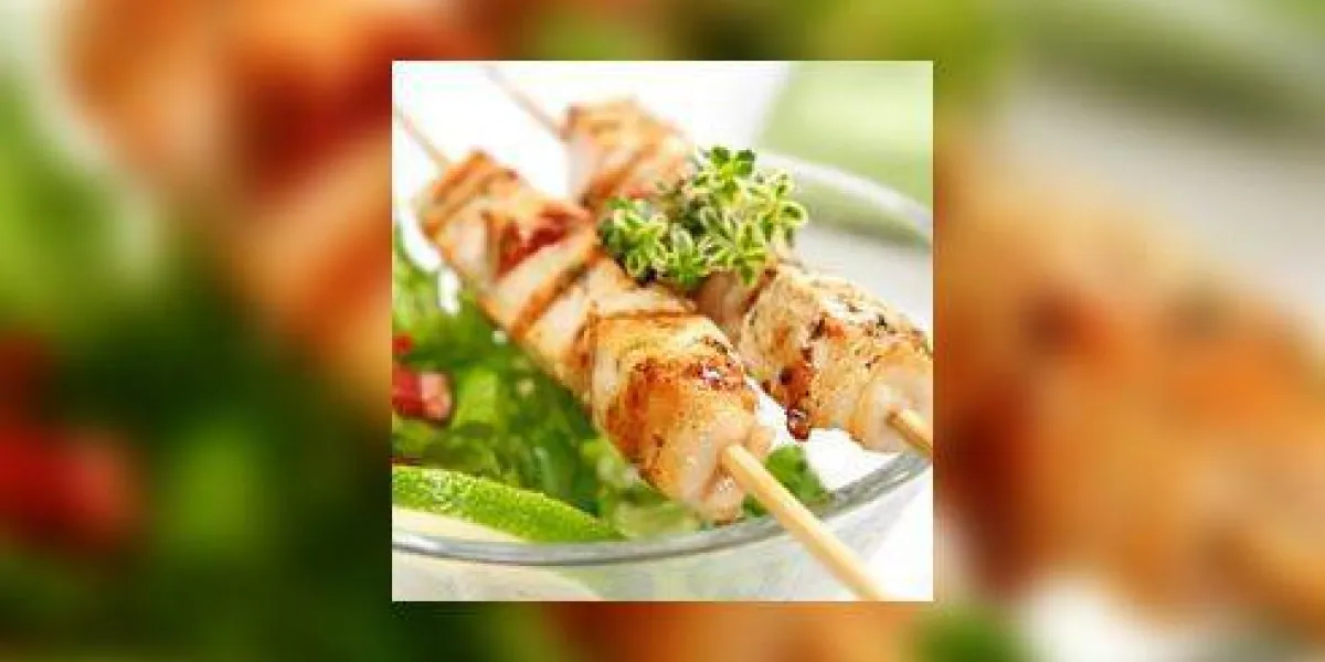 porc (ou poulet) sur un grill craché avec une salade et une tranche de citron vert et de citron-thym comme garniture