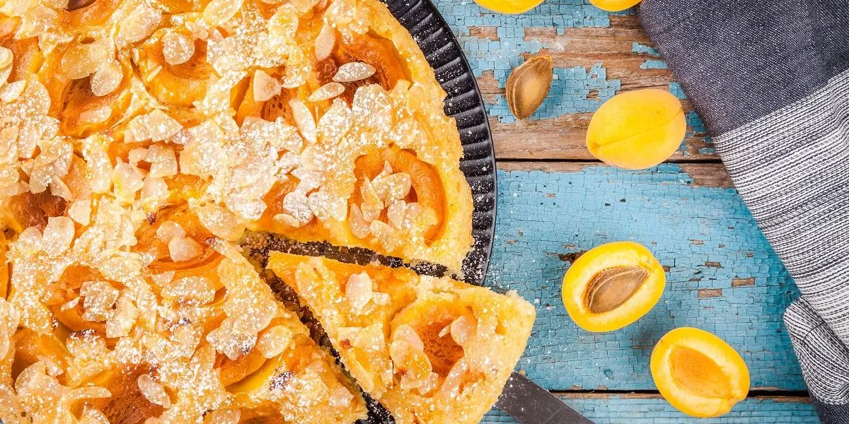 homemade pie with apricots and almonds on wooden rustic background