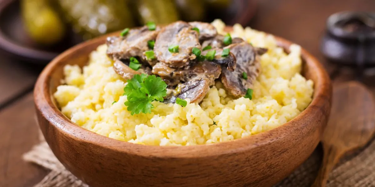 bouillie de millet avec des champignons dans un bol en bois bouillie de millet avec des champignons dans un bol en bois
