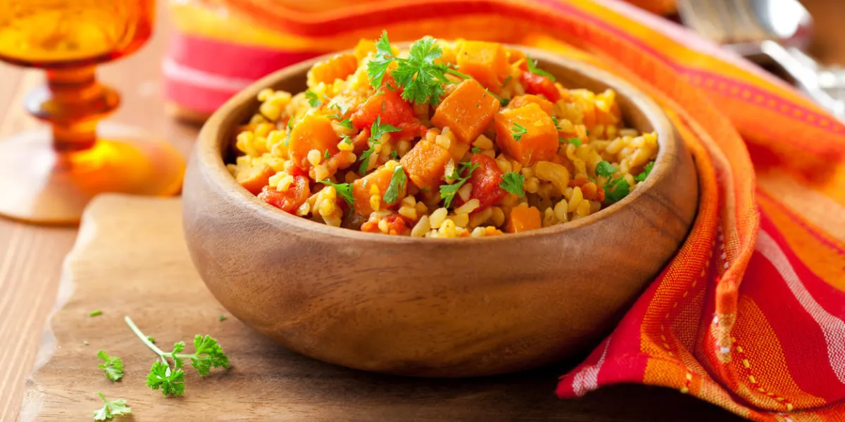 bulgur with tomatoes and butternut squash in the wooden bowl bulgur with tomatoes and butternut squash in the wooden bowl