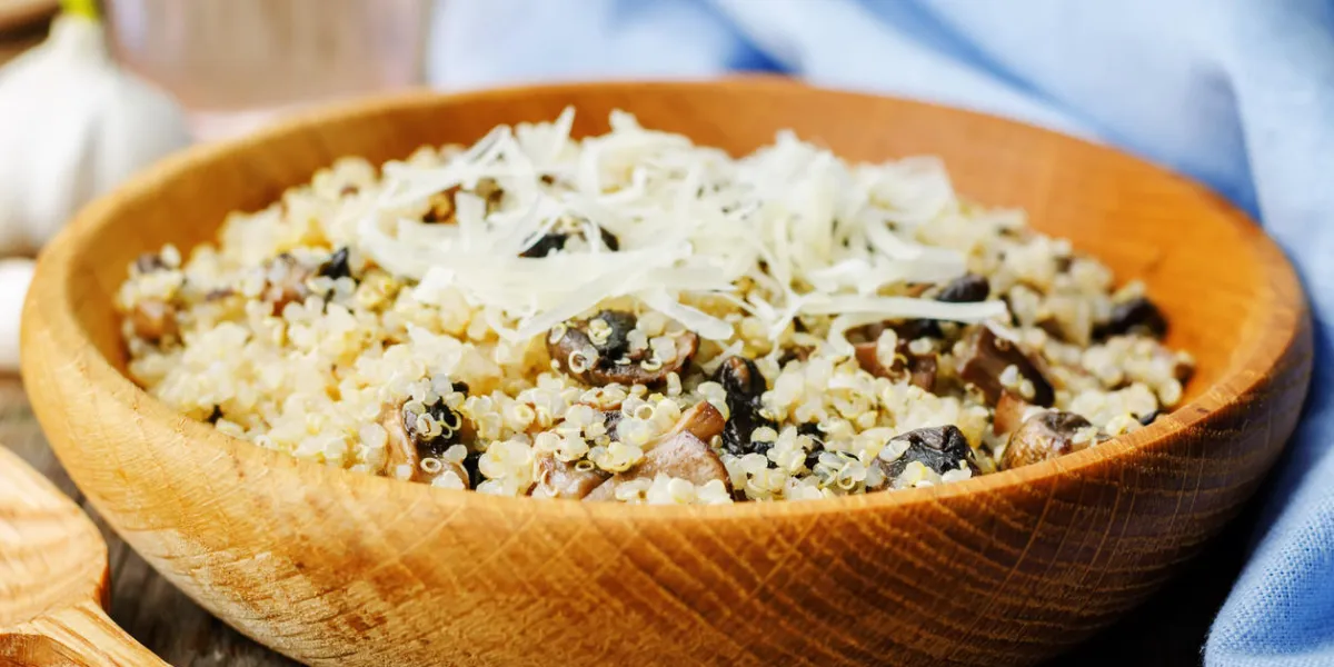 quinoa aux champignons et à l'ail sur un fond de bois foncé quinoa aux champignons et à l'ail sur un fond de bois foncé