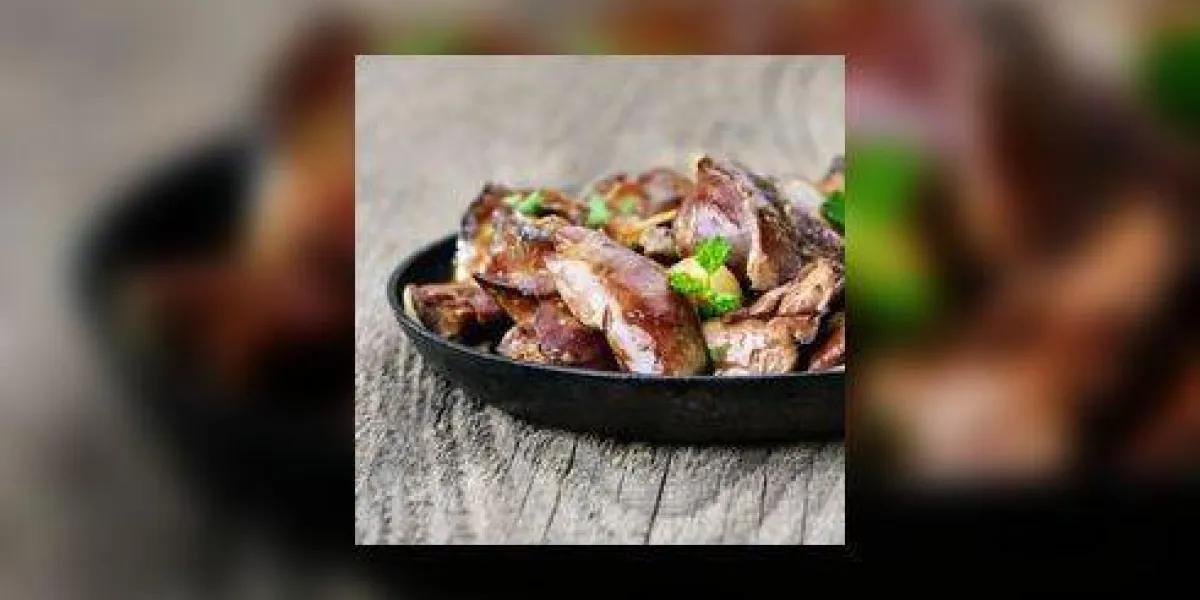 foie de poulet dans une poêle sur la table en bois