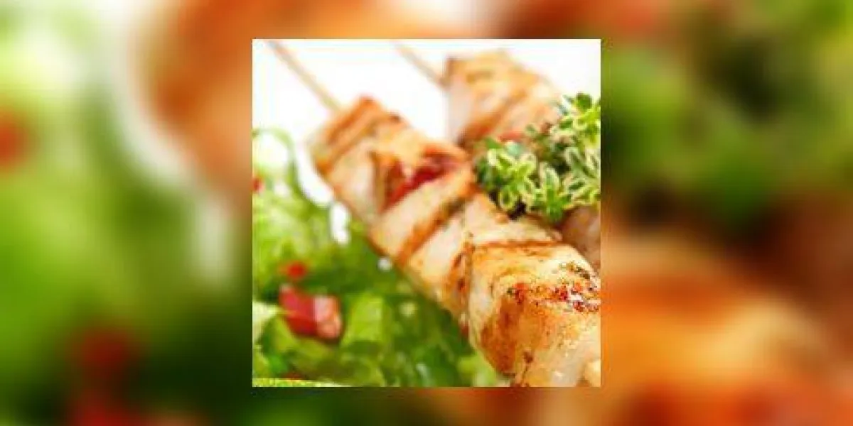 porc (ou poulet) sur un grill craché avec une salade et une tranche de citron vert et de citron-thym comme garniture