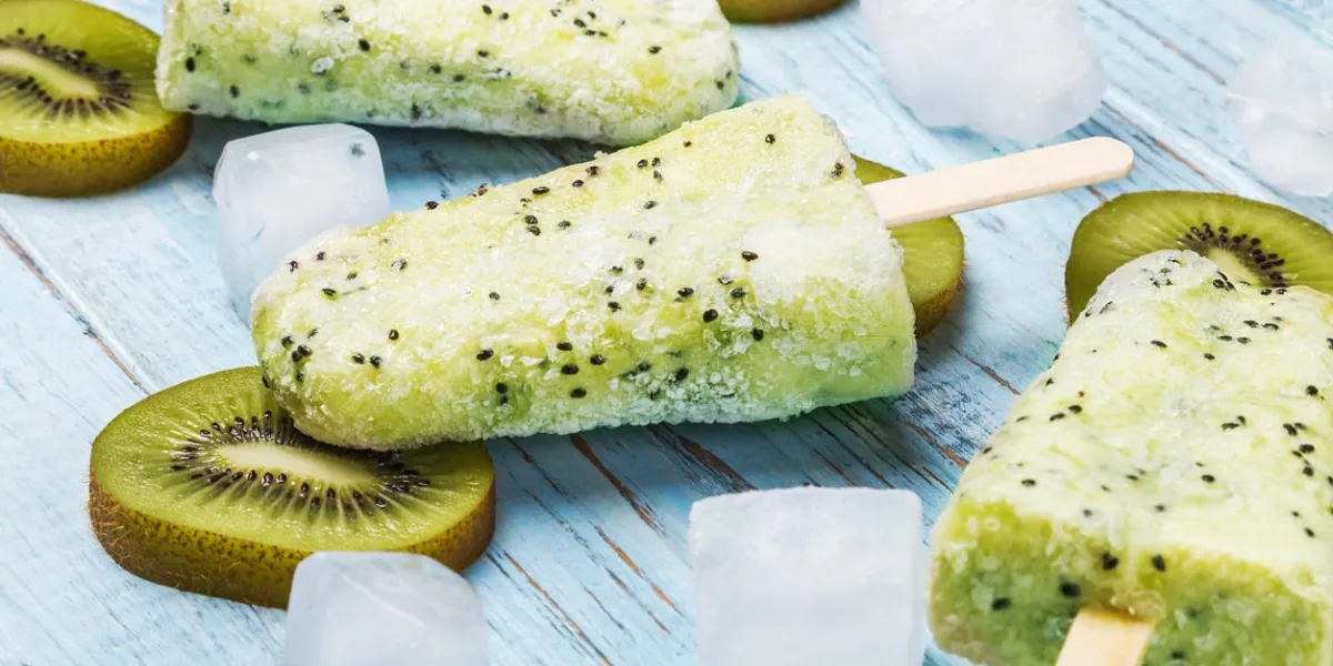 popsicles on a stick of kiwi and lime on a wooden table