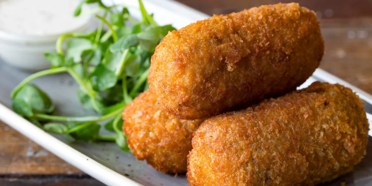 trois petit pain pané frit contenant de la nourriture, purée de pommes de terre, poisson ou viande