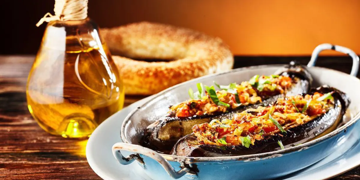 délicieux brinjal frais, aubergine ou aubergine avec une farce végétarienne épicée savoureuse servie dans un plat en métal avec un bretzel et l'huile d'olive