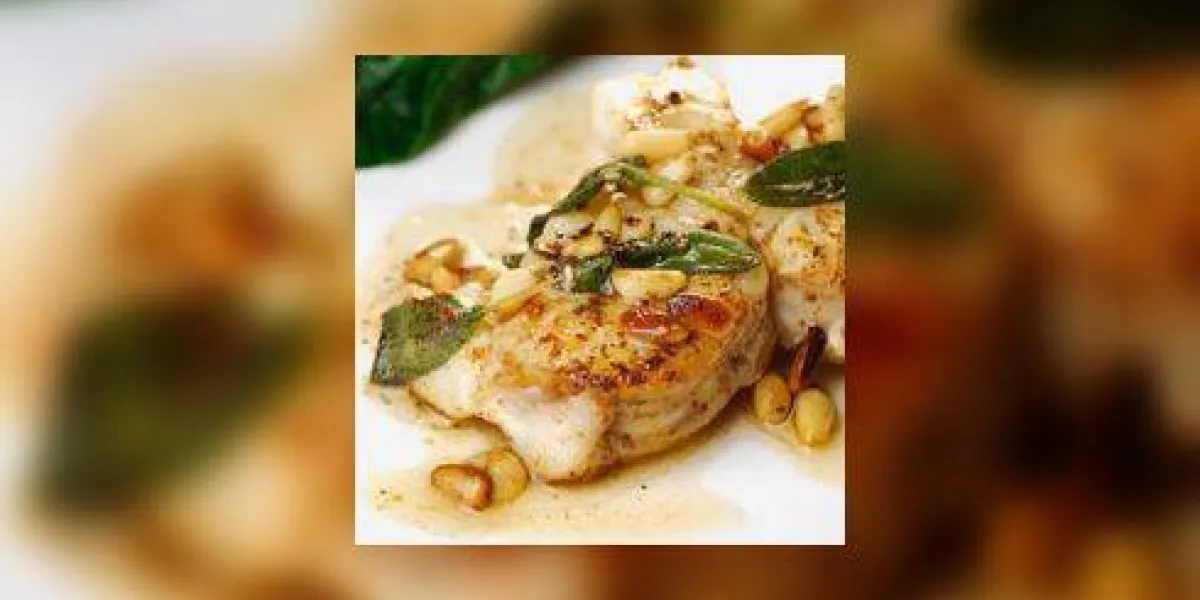 lotte frite avec beurre et sauge et pignons de pin, ail frit et quelques épinards verts en arrière-plan