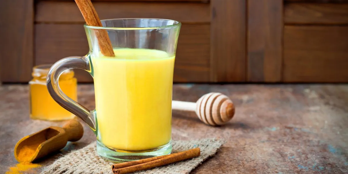 lait d'or curcuma lait latte avec des bâtons de cannelle et de miel detox brûleur de graisse du foie, immunitaire booster, anti inflammatoire sain cosy boisson copie espace lait d'or curcuma lait latte avec des bâtons de cannelle et de miel detox brûleur de graisse du foie, immunitaire booster, anti inflammatoire sain cosy boisson copie espace