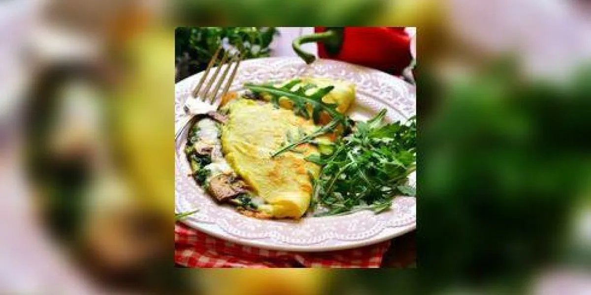 omelette farcie aux épinards et champignons sur une plaque blanche omelette farcie aux épinards et champignons sur une plaque blanche