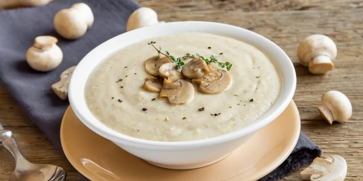 mushroom cream soup with herbs and spices over rustic wooden background mushroom cream soup with herbs and spices over rustic wooden background
