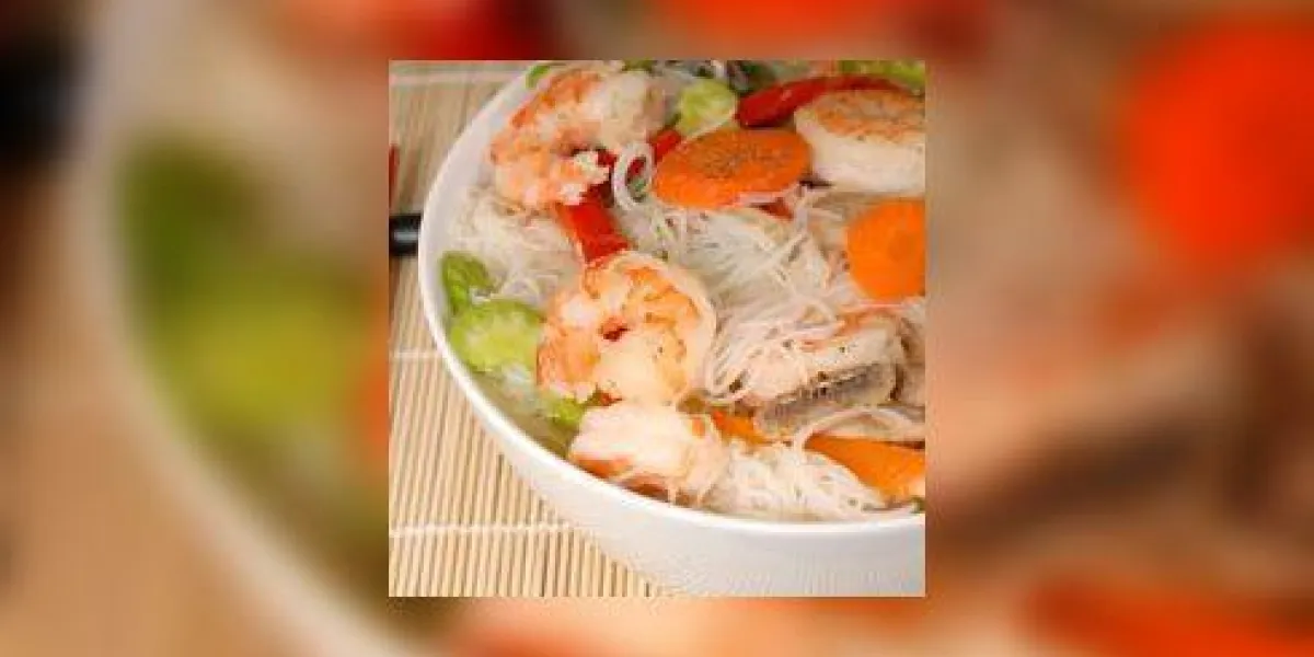 un bol de nouilles udon avec des légumes et des fruits de mer closeup